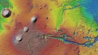 A satellite photo of mars showing the scar's location compared to Tharsis , Olympus Mons and Valles Marineris