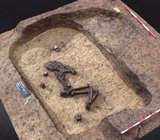 A photo showing a skeleton lying on its side in the burial mound